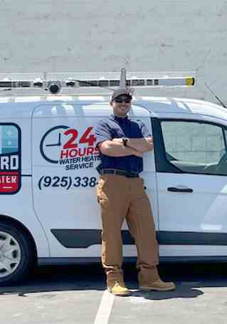 Service technician standing next to a fully equipped van for same day water heater repair service