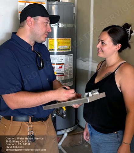 A technician is explaining the warranty protection for a newly installed water heater to a customer in Concord.